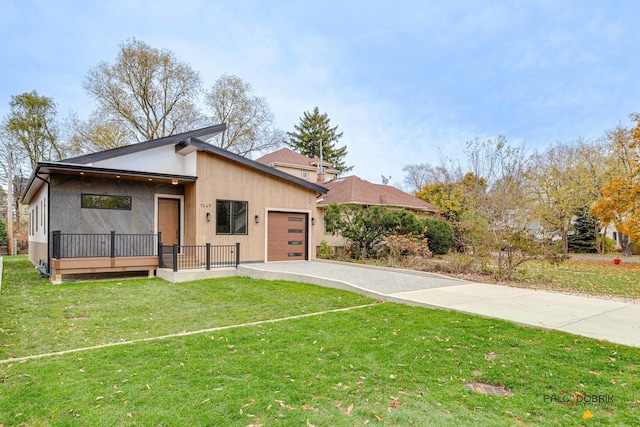 view of front of property featuring a garage, driveway, and a front yard