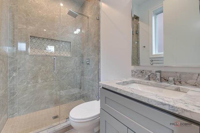 bathroom with toilet, a stall shower, and vanity