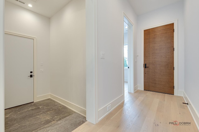 entryway with recessed lighting, visible vents, baseboards, and wood finished floors