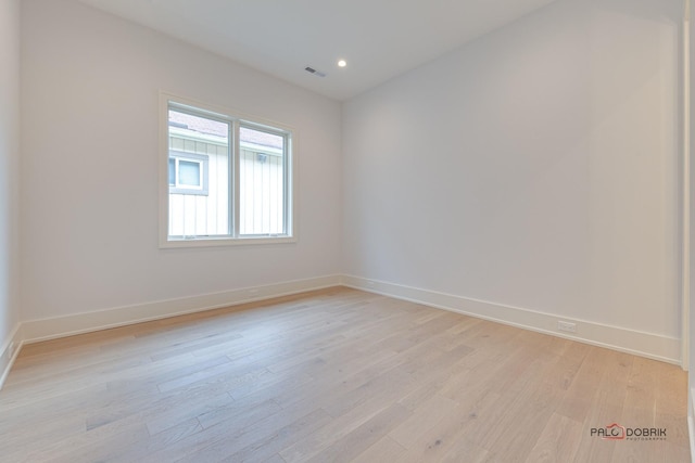 empty room featuring light wood-style flooring, recessed lighting, visible vents, and baseboards