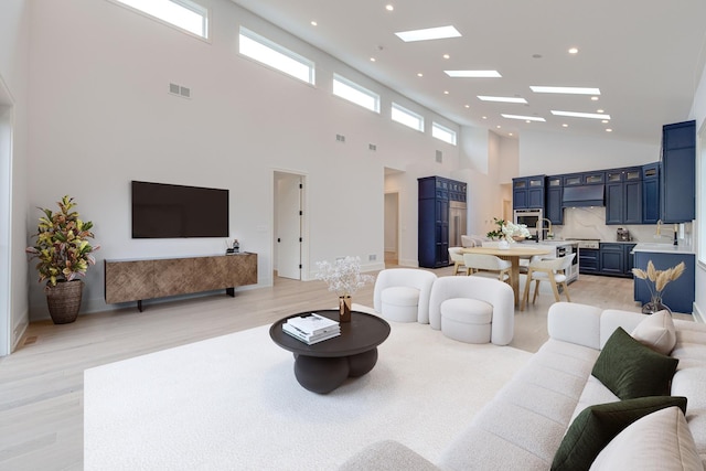 living room with recessed lighting, visible vents, and light wood-style floors