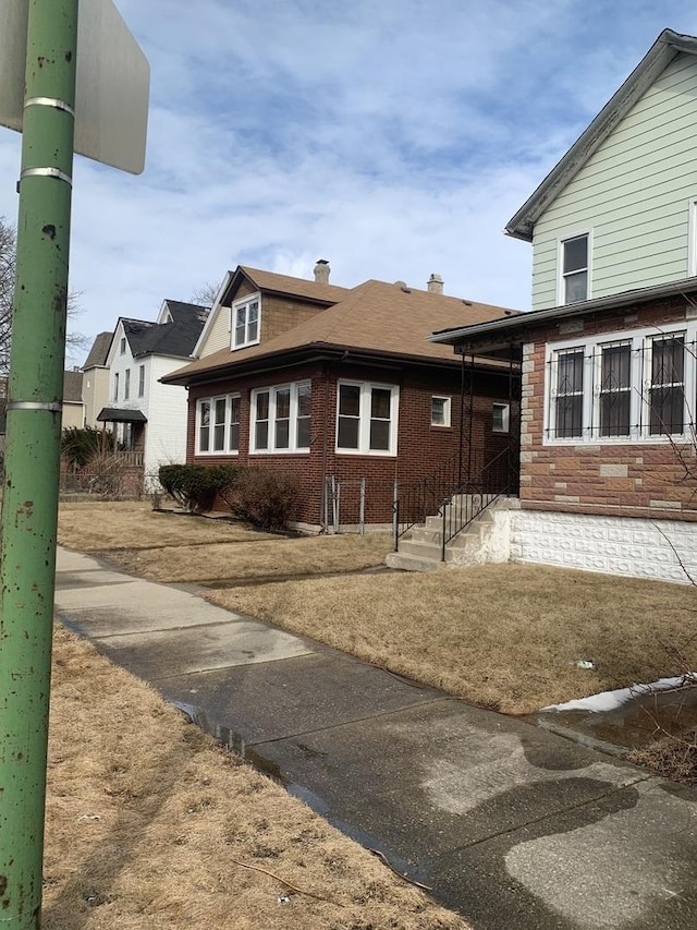 view of front of property with brick siding and a chimney