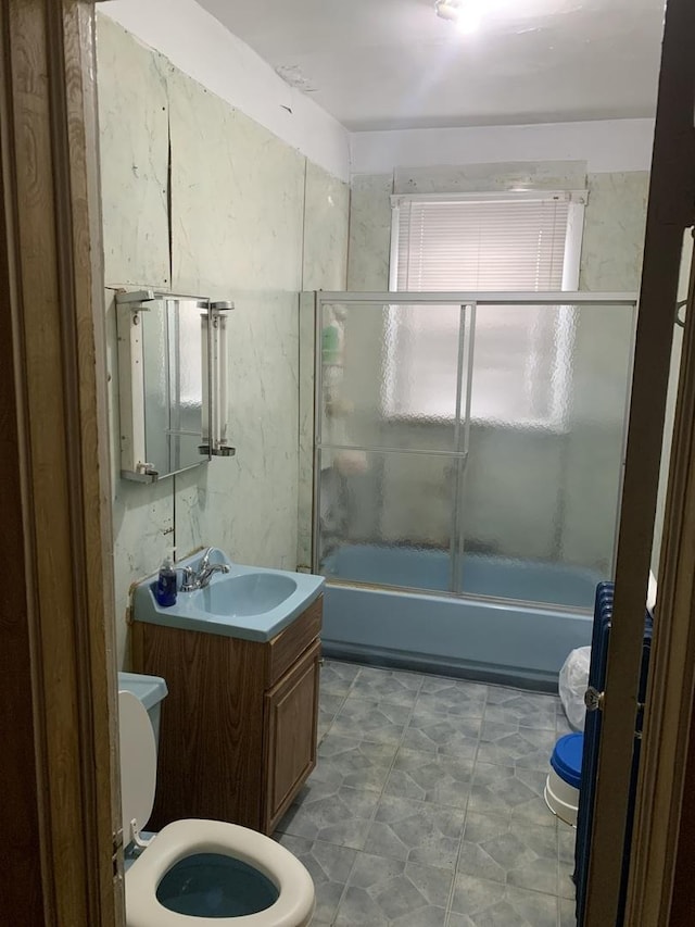 full bath featuring bathtub / shower combination, vanity, toilet, and tile walls