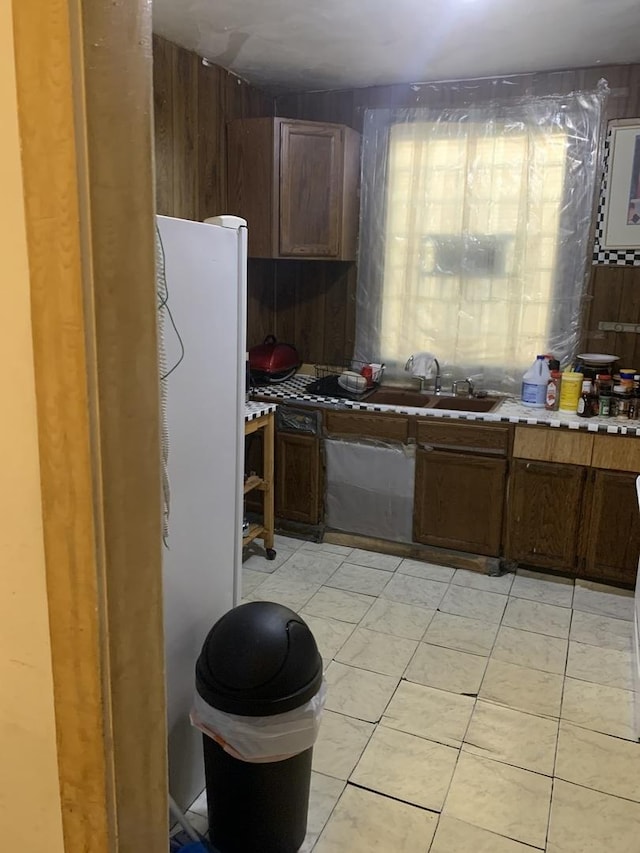 kitchen featuring light tile patterned floors and a sink