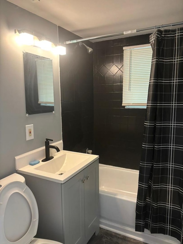 bathroom featuring toilet, shower / tub combo, and vanity