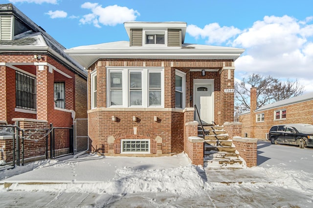 view of front of home with a gate and brick siding