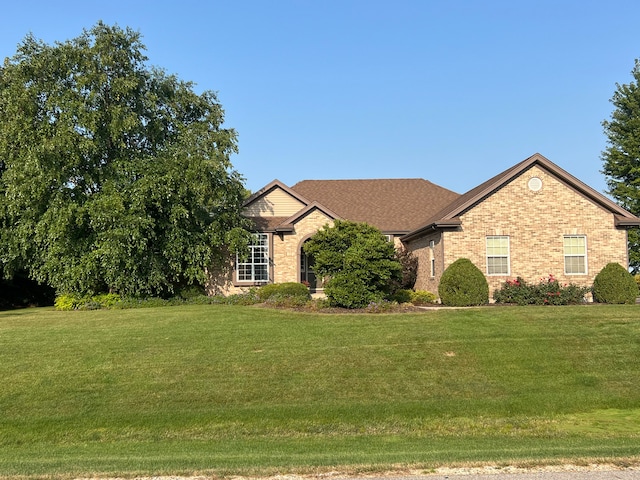 view of front of house with a front yard and brick siding