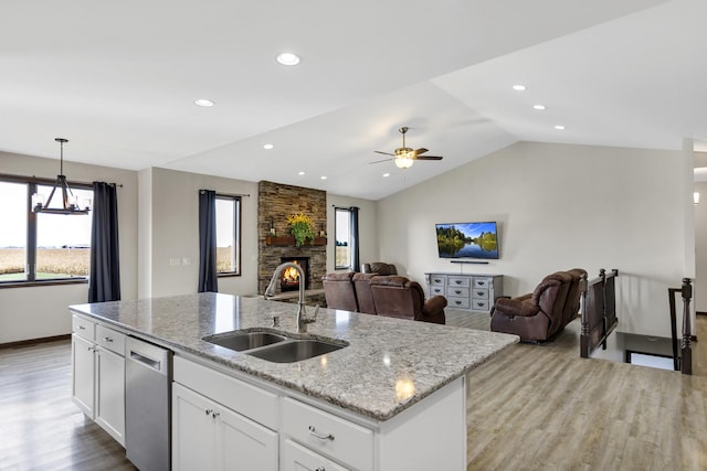 kitchen with open floor plan, white cabinetry, a sink, an island with sink, and dishwasher