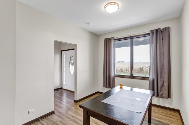 dining space featuring wood finished floors and baseboards