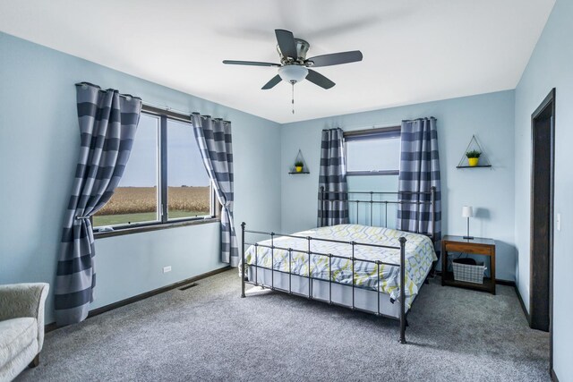 bedroom featuring carpet floors, multiple windows, visible vents, and baseboards