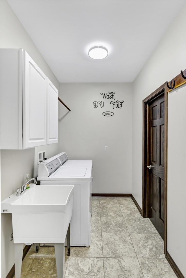 washroom featuring cabinet space, baseboards, independent washer and dryer, a sink, and light tile patterned flooring