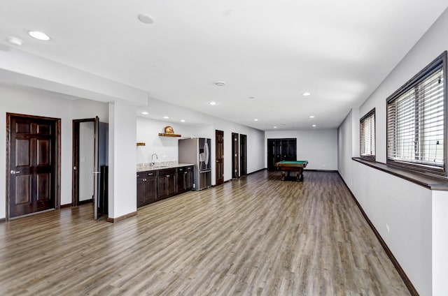 unfurnished living room featuring recessed lighting, light wood-style flooring, a sink, billiards, and baseboards