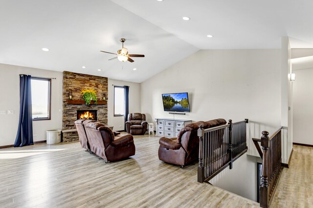 living room featuring lofted ceiling, a fireplace, light wood-style flooring, and recessed lighting