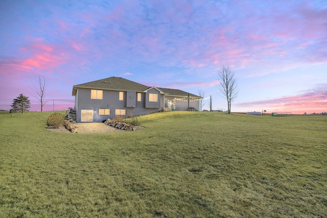 rear view of house featuring a yard and an attached garage