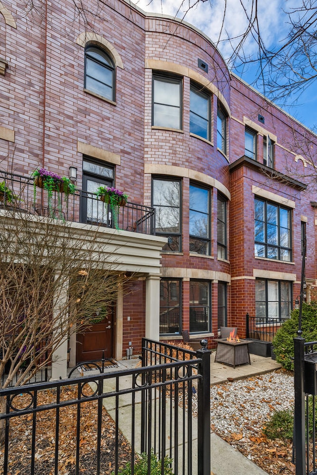 view of front of property featuring brick siding and a fenced front yard