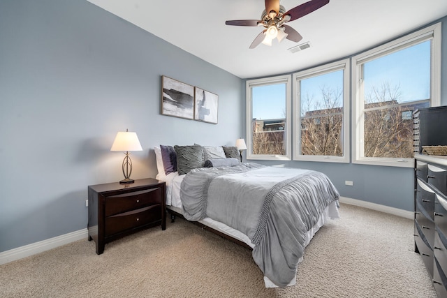 bedroom featuring a ceiling fan, light colored carpet, visible vents, and baseboards