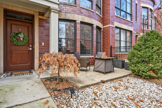 entrance to property featuring brick siding