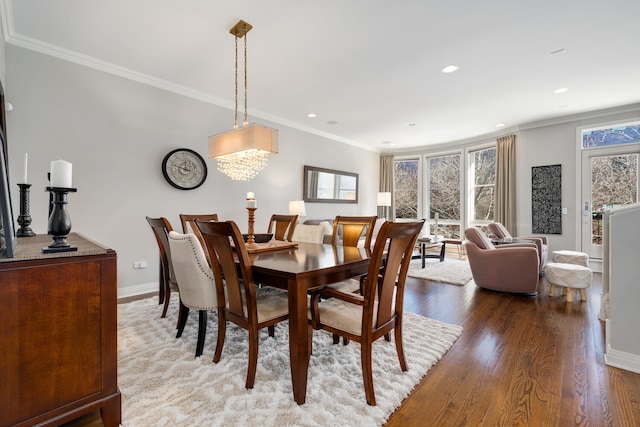 dining area with crown molding, baseboards, a wealth of natural light, and wood finished floors