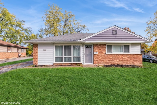 ranch-style house with a front yard and brick siding