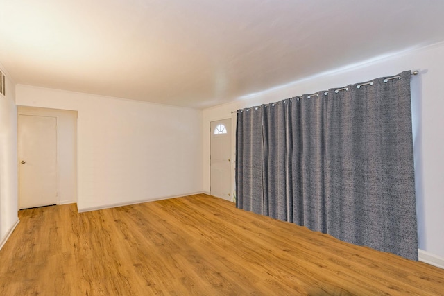 empty room featuring light wood-style floors and baseboards