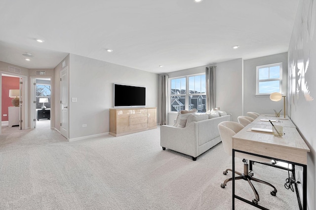 living room with a healthy amount of sunlight, light colored carpet, visible vents, and baseboards