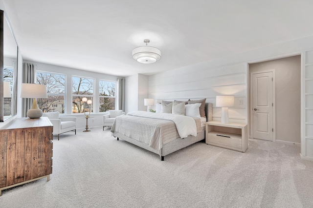 bedroom with baseboards and light colored carpet