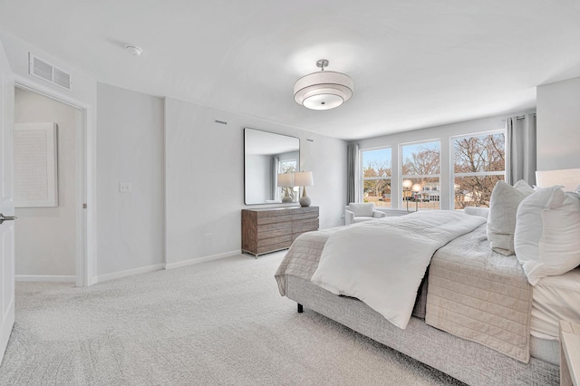 bedroom featuring visible vents, light carpet, baseboards, and multiple windows