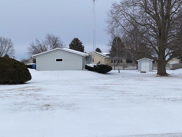 yard layered in snow with a storage shed and an outbuilding