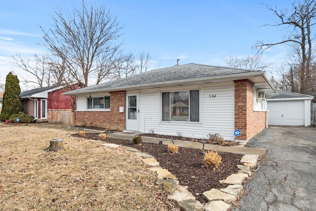 single story home with an outbuilding, brick siding, driveway, and roof with shingles