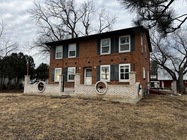 colonial home with brick siding and a front lawn