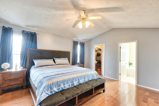 bedroom with lofted ceiling, light wood-style flooring, a spacious closet, and a closet