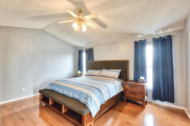 bedroom with baseboards, vaulted ceiling, and wood finished floors