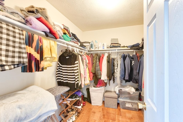 walk in closet with wood finished floors