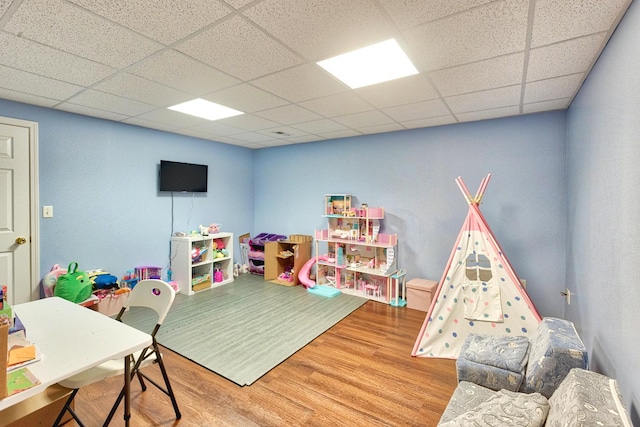 playroom with a drop ceiling and wood finished floors