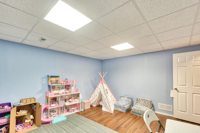 game room featuring a drop ceiling, wood finished floors, and visible vents