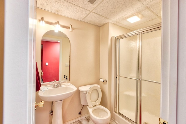 full bathroom featuring a paneled ceiling, a stall shower, and toilet