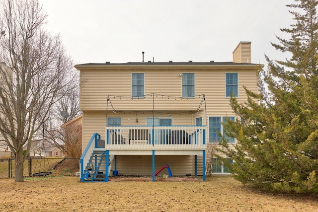 rear view of house featuring stairway, a chimney, fence, and a wooden deck