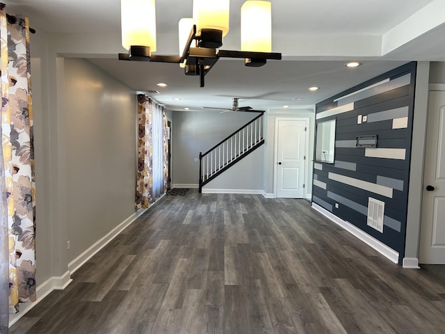 unfurnished living room featuring dark wood-type flooring, baseboards, ceiling fan, stairs, and recessed lighting