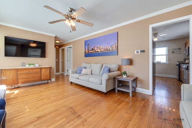 living area with light wood-style floors, ceiling fan, baseboards, and crown molding