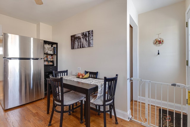 dining area with ceiling fan, wood finished floors, and baseboards