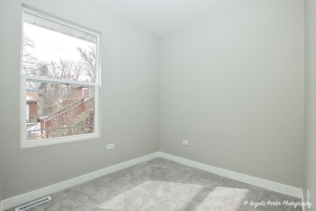 unfurnished room featuring carpet floors, baseboards, and visible vents