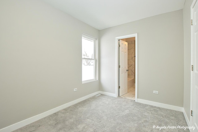 unfurnished bedroom featuring light carpet and baseboards