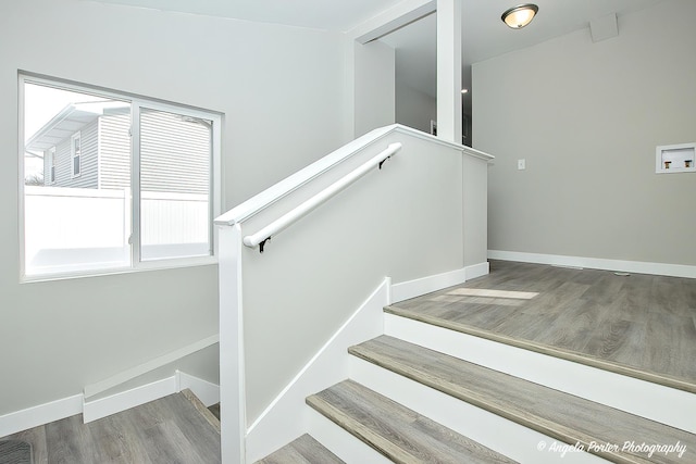 staircase with visible vents, baseboards, and wood finished floors