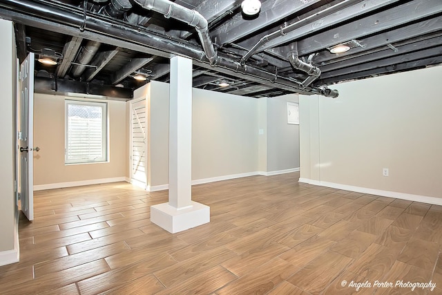 basement featuring baseboards and wood finished floors