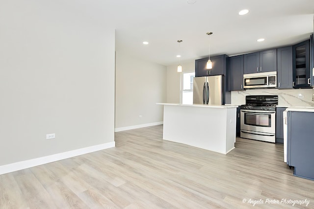 kitchen with stainless steel appliances, baseboards, light countertops, backsplash, and light wood finished floors