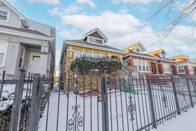 view of front of house with a fenced front yard, a gate, and brick siding