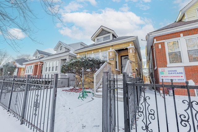 bungalow featuring a fenced front yard and a gate