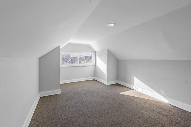 empty room featuring stairs, dark colored carpet, visible vents, and baseboards