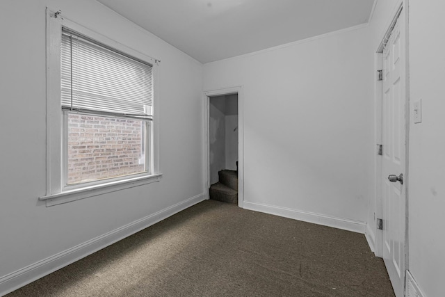 unfurnished room with dark carpet, stairway, and baseboards