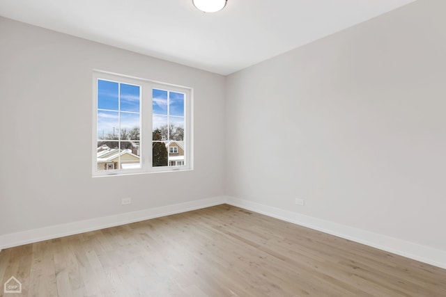 spare room featuring light wood-type flooring and baseboards